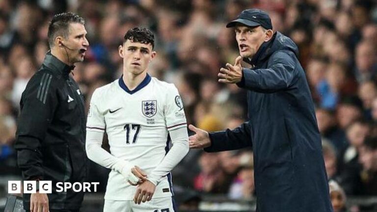 Thomas Tuchel gesticulates while standing next to Phil Foden